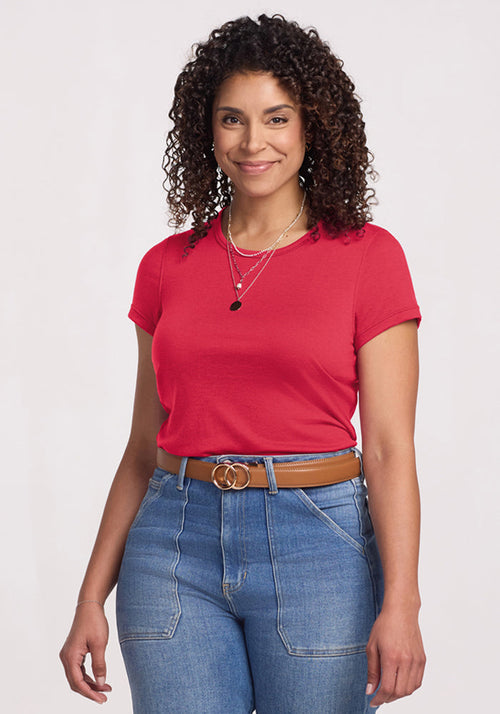 Smiling woman with curly hair wears Woolx Addie Crew Neck - Berry Ice Pop and blue jeans against a light background. | Kisha is 5'8", wearing a size M