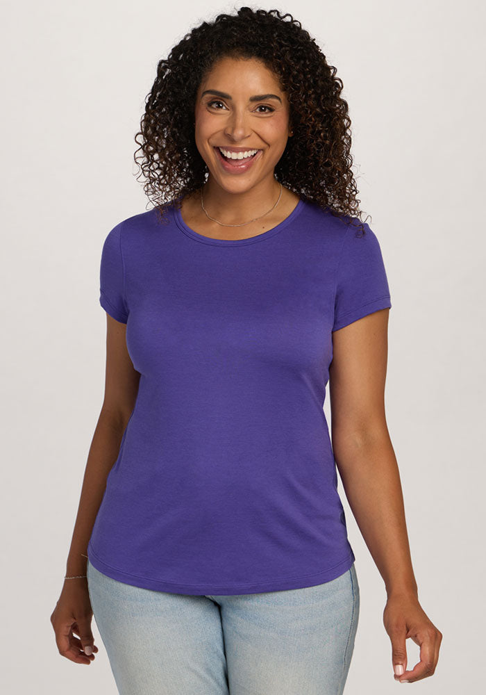 Smiling woman wears Woolx Addie Crew Neck - Berry Indigo and light blue jeans against a plain background. | Kisha is 5'8", wearing a size M