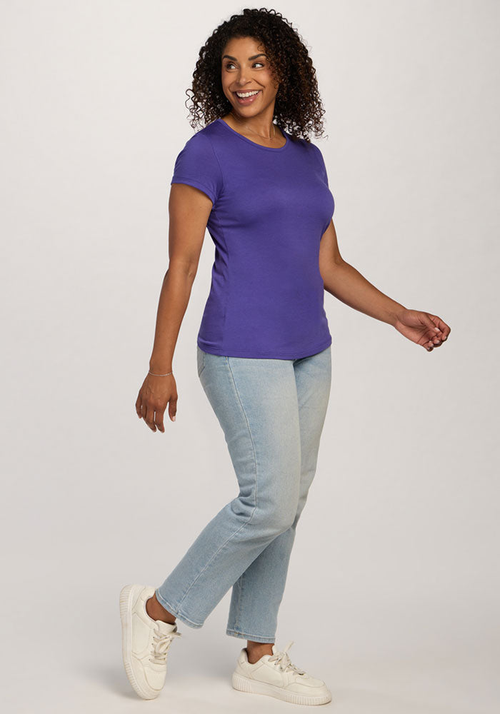 Woman smiling and walking, wearing the Woolx Addie Crew Neck in Berry Indigo, light blue jeans, and white sneakers.
