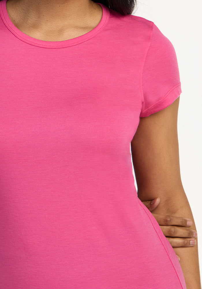 A person wearing the Woolx Addie Crew Neck in Raspberry Fizz, with one hand resting on their hip.