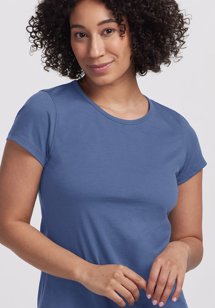 Smiling woman with curly hair wears Woolx Addie Crew Neck • Final Sale - Skyline against a light background.
