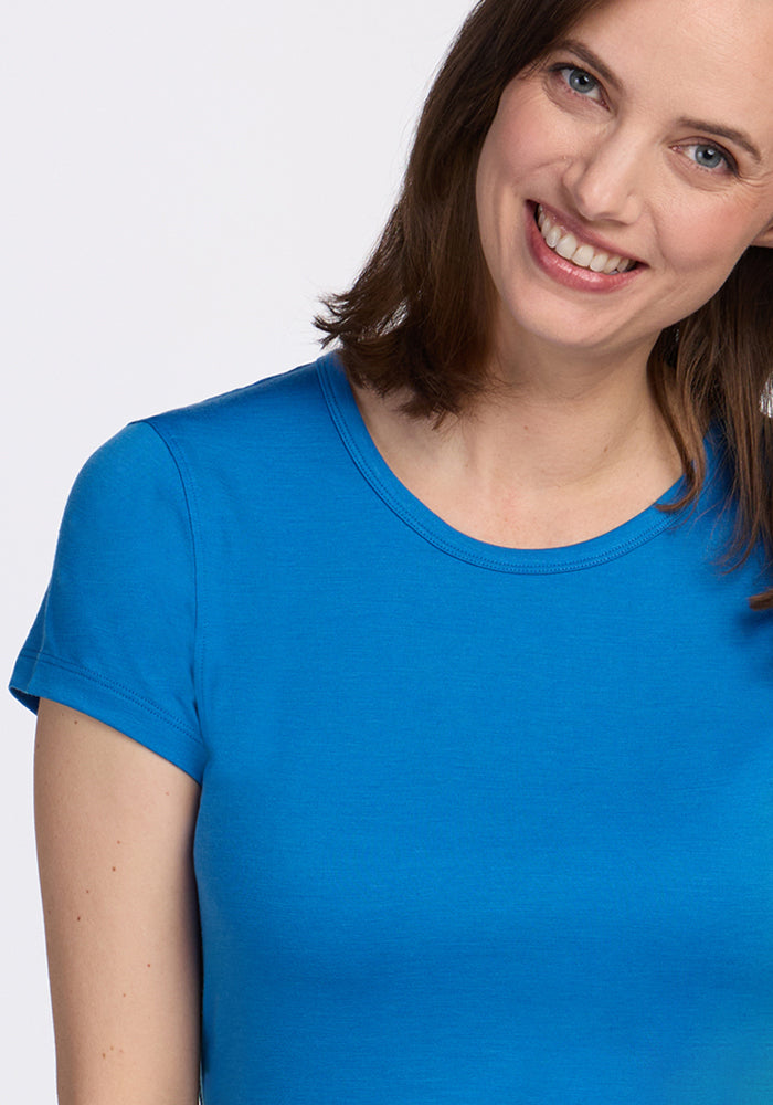 Woman with shoulder-length brown hair smiles in a Woolx Addie Crew Neck • Final Sale - Wave Rider shirt.