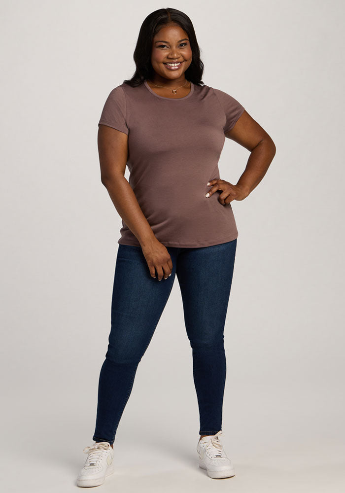Woman smiling in a Woolx Addie Crew Neck - Peppercorn, dark jeans, and white sneakers against a light background.