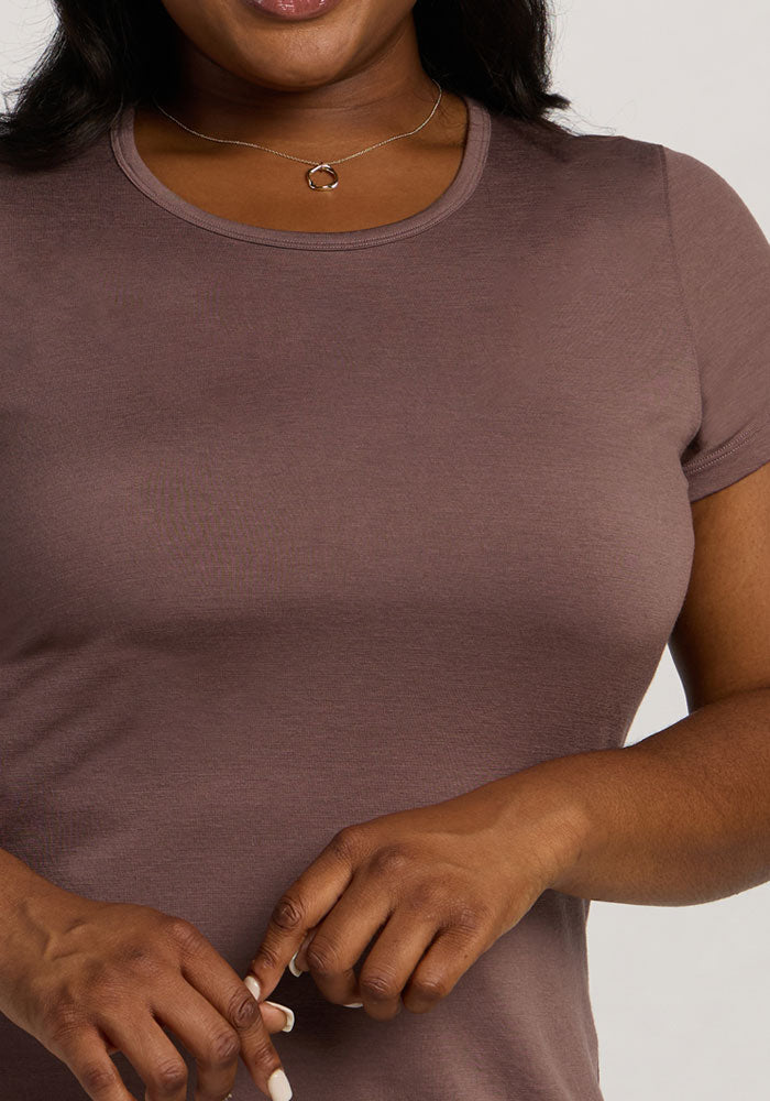 Woman in Woolx Addie Crew Neck - Peppercorn, hands clasped at waist, necklace visible; torso and lower face shown.