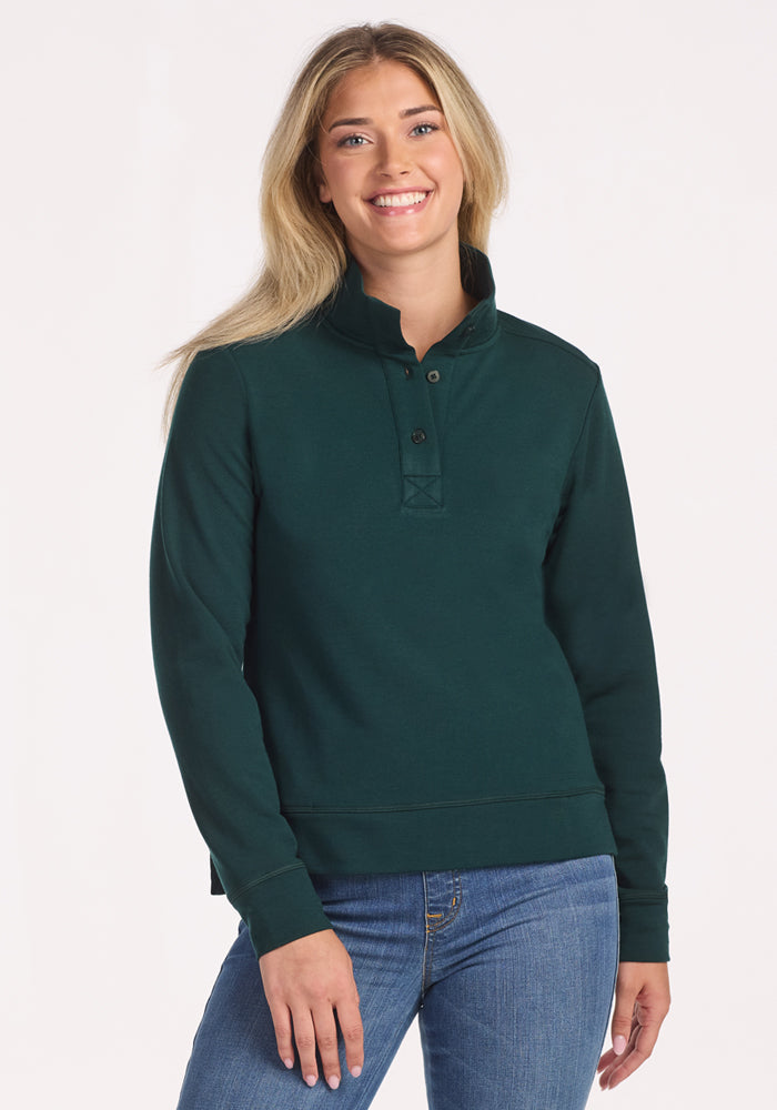 A woman smiles at the camera, cozy in the Woolx Annie 3 Button Pullover • Final Sale - Deep Timber.