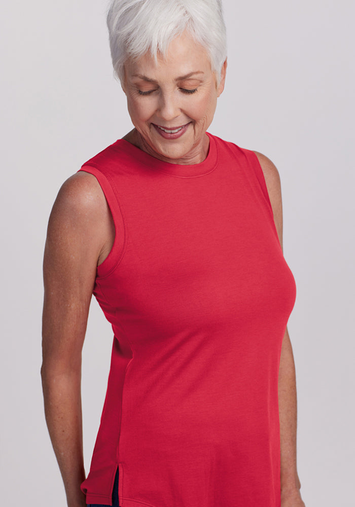 Older woman with short white hair smiles, wearing the Woolx Bella Tunic Top - Berry Ice Pop against a plain background.