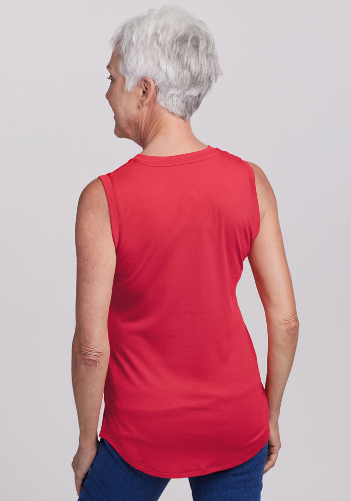 Older woman wearing the Woolx Bella Tunic Top in Berry Ice Pop with blue jeans, shown from the back on a light background.