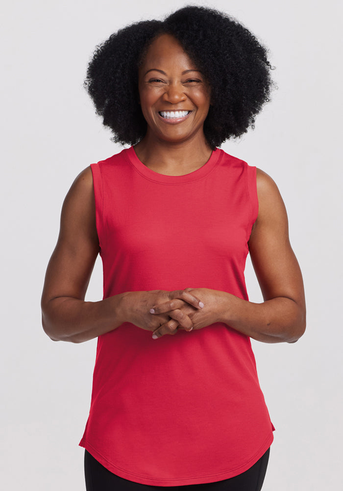 Smiling woman with curly hair wears the Woolx Bella Tunic Top in Berry Ice Pop, standing against a white background. | Pechaz is 5’4”, wearing a size S