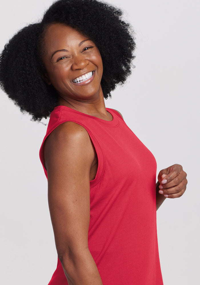 Smiling woman with curly hair wears the Woolx Bella Tunic Top in Berry Ice Pop, posing against a light background.