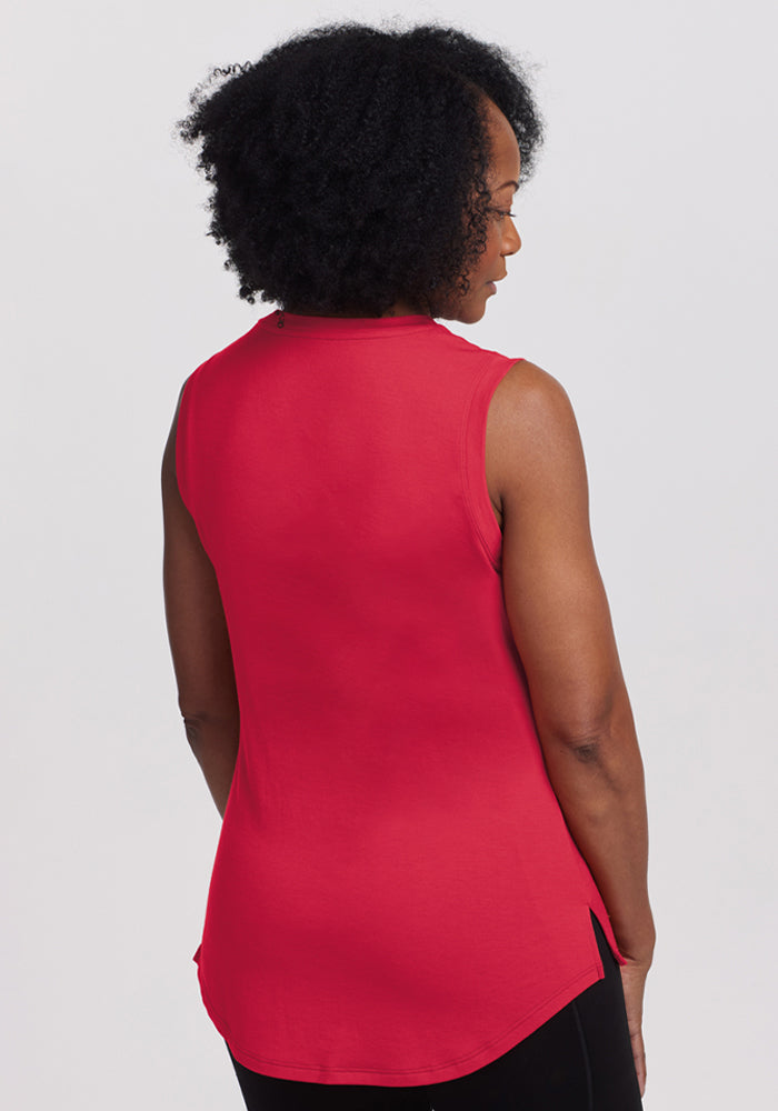 A woman with curly hair models the Woolx Bella Tunic Top in Berry Ice Pop, shown from the back against a light background.