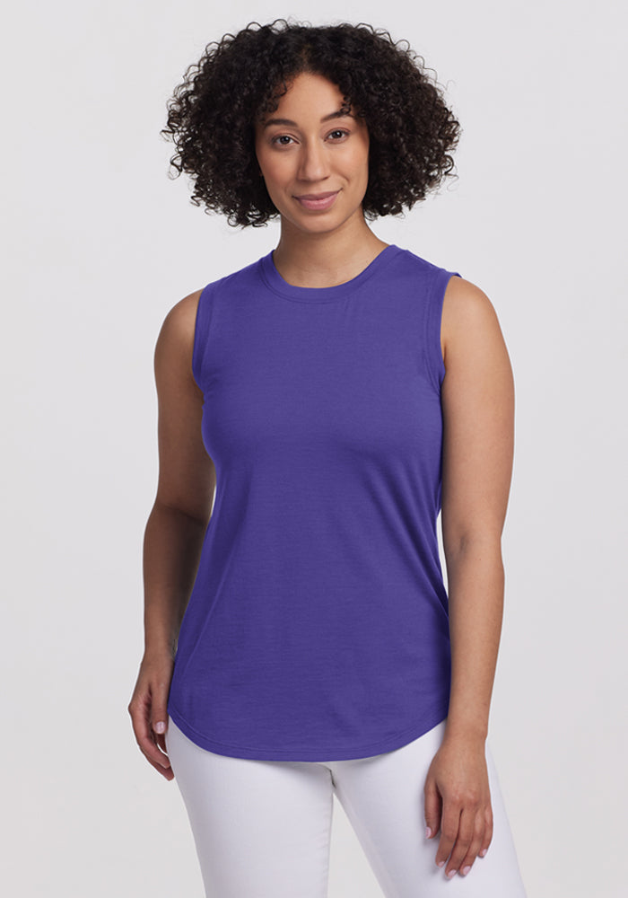 Woman with curly hair wears the Woolx Bella Tunic Top - Berry Indigo and white pants, against a plain light background. | Tori is 5'7", wearing a size S