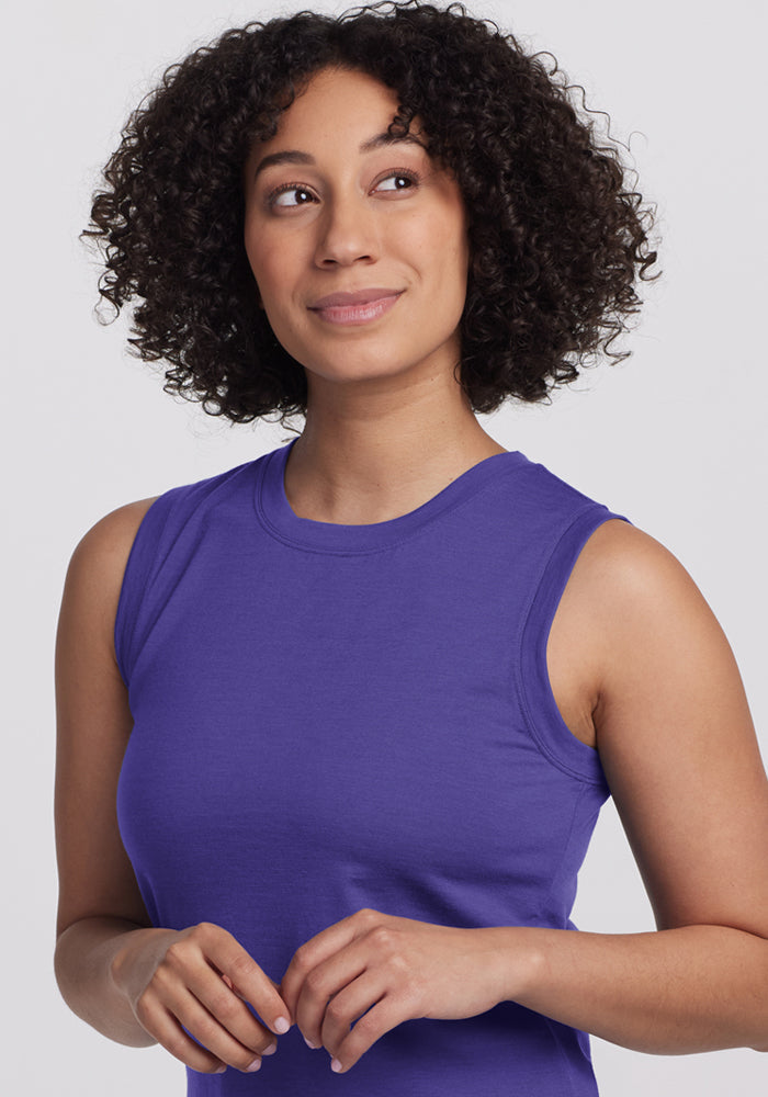 Woman with curly hair in a Woolx Bella Tunic Top - Berry Indigo, looking up and smiling gently.