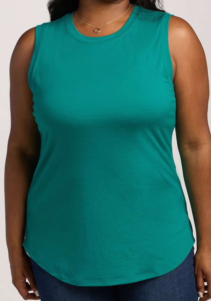 A person wearing the Woolx Bella Tunic Top - Cabana Crush with blue jeans, shown from shoulders to hips.