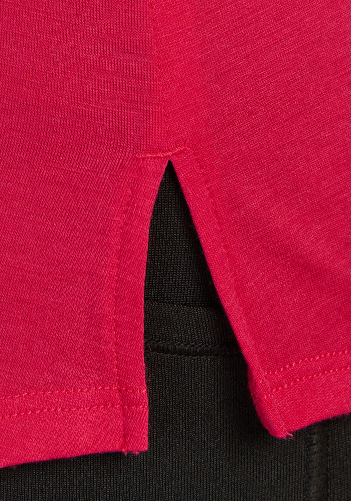 Close-up of Woolx Bella Tunic Top in Poppy Spark, showing side slit and black merino layer underneath. Final Sale.
