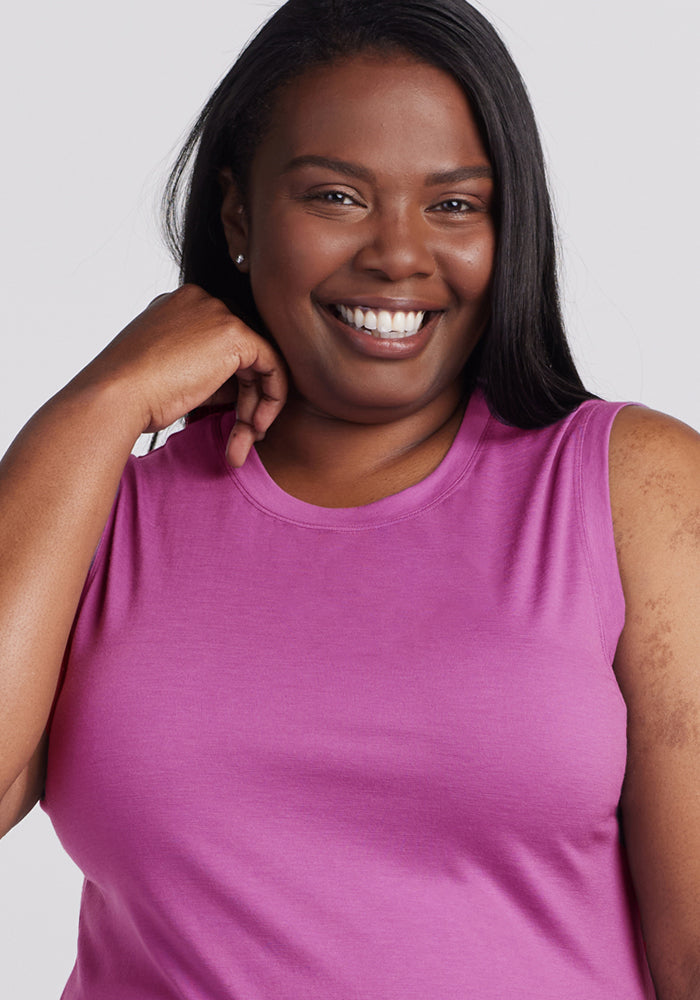 Smiling woman in the Woolx Bella Tunic Top in Purple Wine, hand raised by her face.