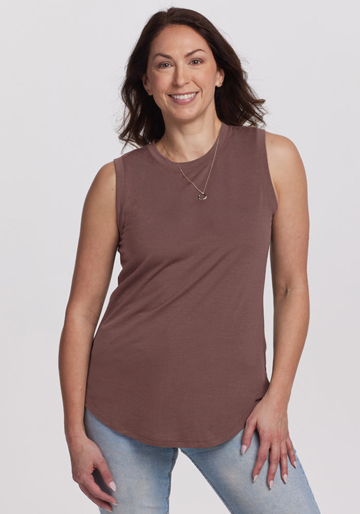 Woman smiles in a Woolx Bella Tunic Top in Peppercorn, light blue jeans, and a necklace against a plain background. | Tiffany is 5’8”, wearing a size S