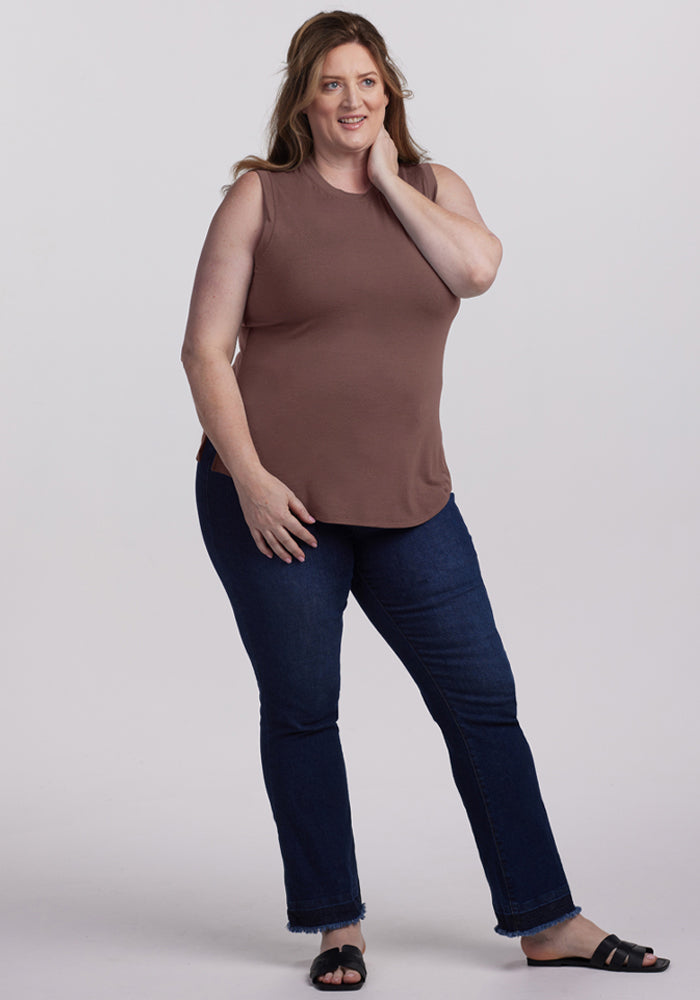 Woman with long brown hair in a Woolx Bella Tunic Top - Peppercorn, dark jeans, and sandals, smiling.