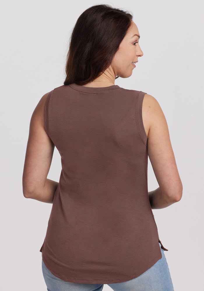 Woman with long brown hair wears the Woolx Bella Tunic Top in Peppercorn and light blue jeans, facing away.