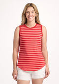 A woman with long blonde hair smiles at the camera wearing the Woolx Bella Tunic Top in Wildberry Stripe and white shorts, standing against a plain white background. | Ariana is 5'11", wearing a size S