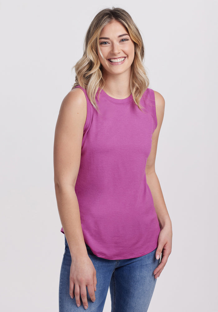 Smiling woman in the Woolx Bella Tunic Top in Purple Wine, final sale, styled with blue jeans and a high neckline.