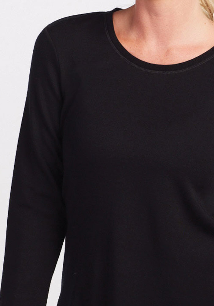 A person wearing the Woolx Blair Tunic in black, a merino wool long-sleeve shirt with a round neckline. The focus is on the upper body and the tunic's texture against a crisp white background.