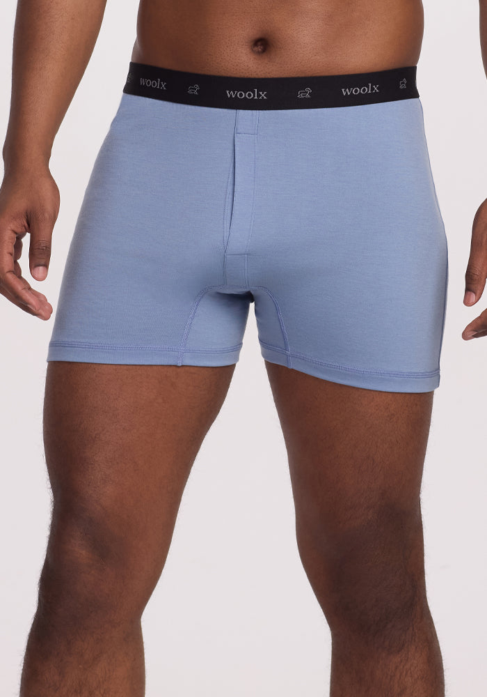A person models Woolx Breathe Boxer Shorts in Stonewash blue, featuring a black Woolx waistband—enjoy breathable comfort from Australian Merino Wool. Final sale.