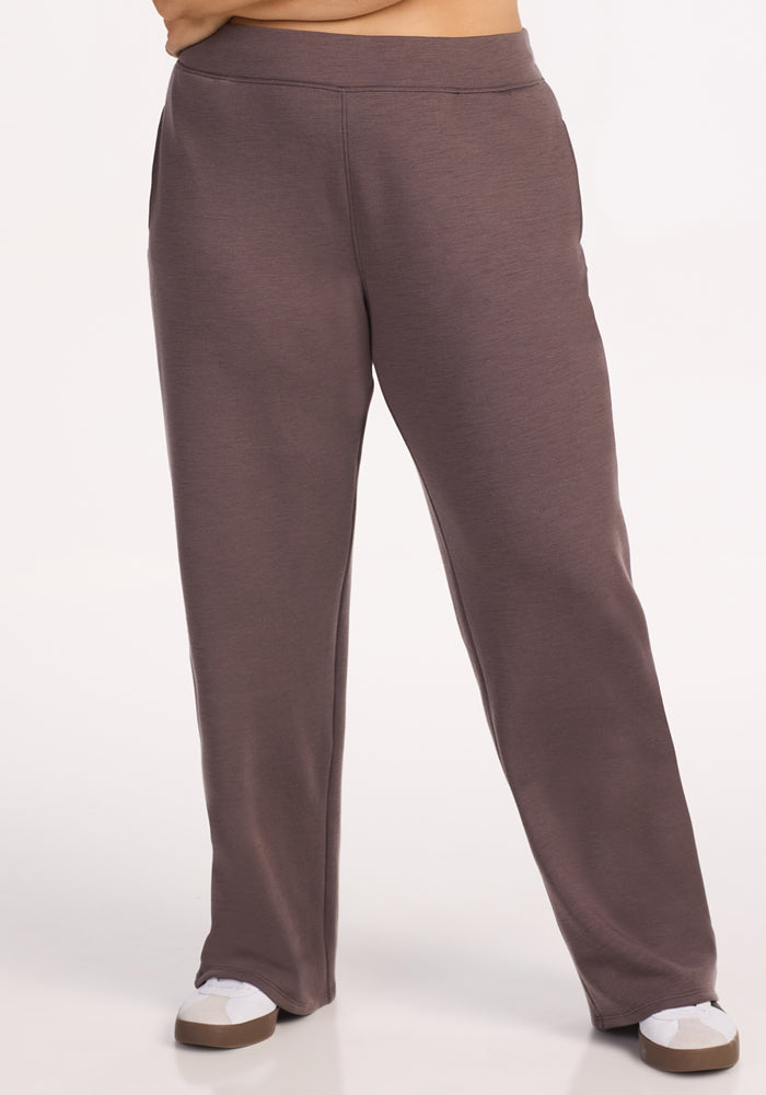 A person wears Woolx Bree Lounge Pants in Plum Truffle, hands in side pockets, paired with white sneakers. The relaxed fit pants are shown waist down against a plain, light background. Final Sale.