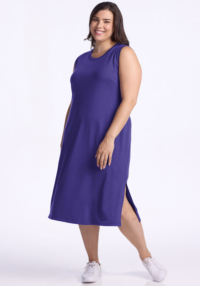 Smiling woman in the Woolx Cassie Dress - Berry Indigo with side slit and sneakers—perfect for travel.