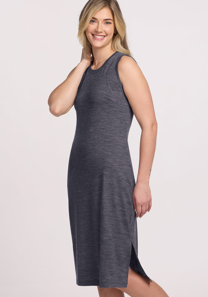 Woman smiles in the Woolx Cassie Dress in Cinder Melange, a knee-length, sleeveless, wrinkle-resistant Merino wool style.