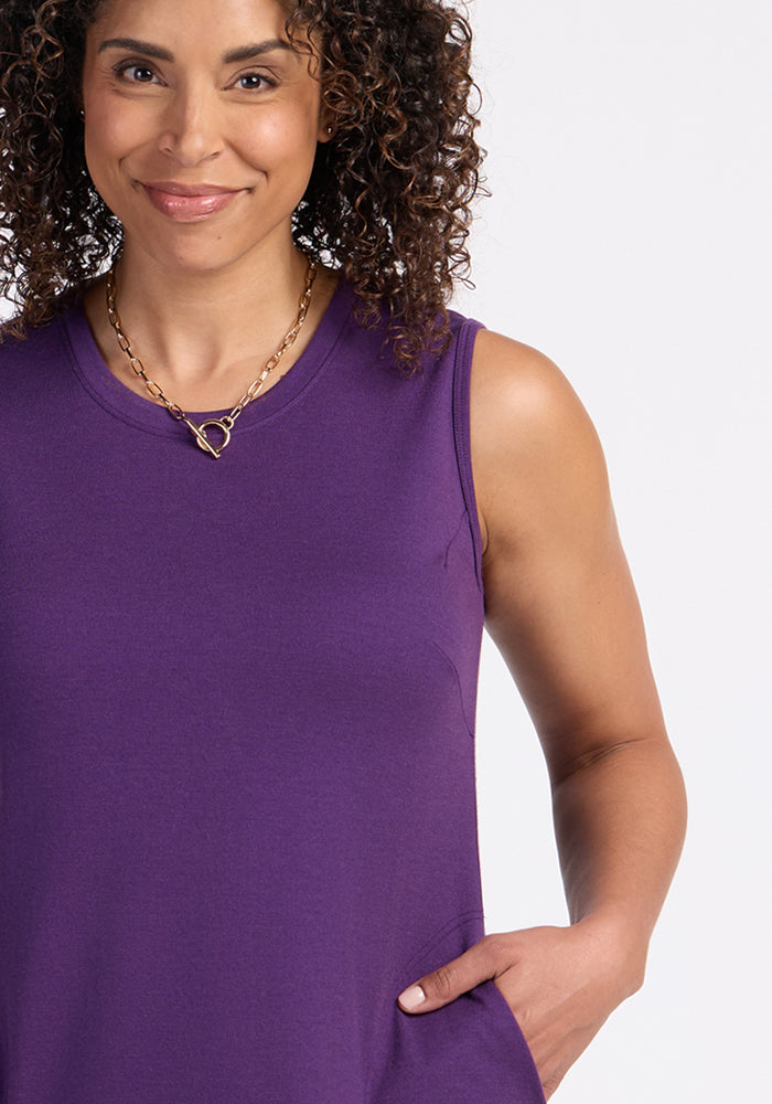 Smiling woman in the Woolx Cassie Dress•Final Sale - Plum Crush, with hand in pocket and gold heart necklace.