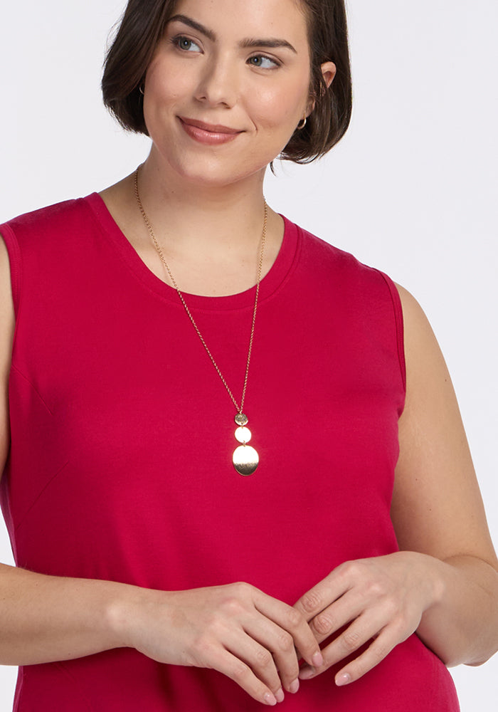 Woman in the Woolx Cassie Dress in Poppy Spark, smiling with a gold necklace, looking slightly to the side.