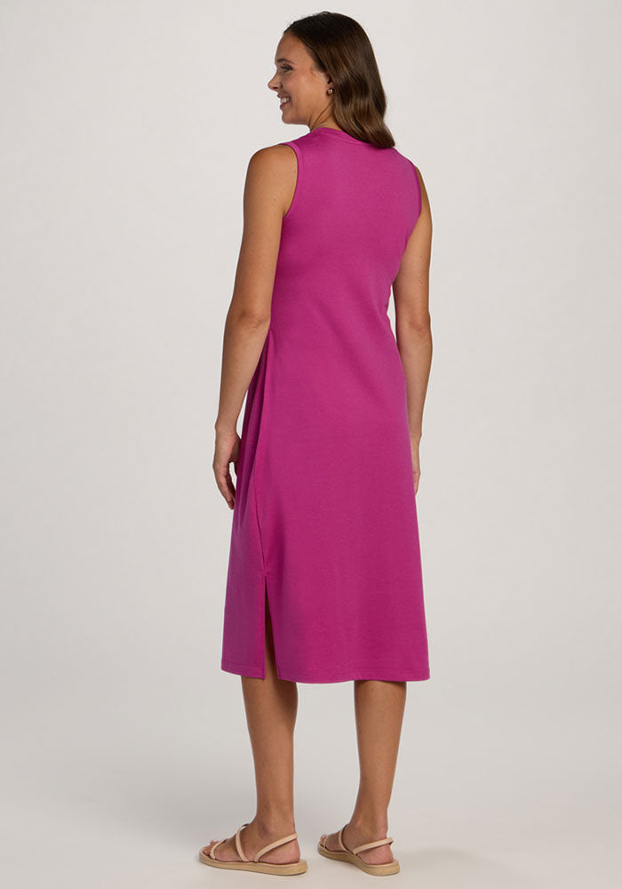 Woman in the wrinkle-resistant Woolx Cassie Dress in Summer Sorbet and sandals, smiling with her back to the camera.