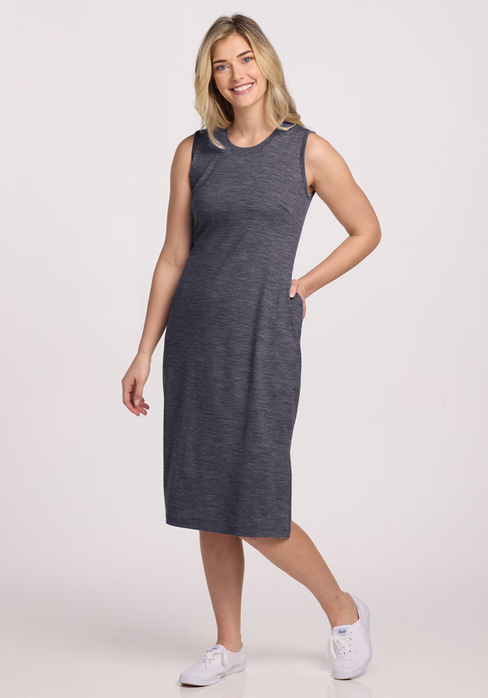 Smiling woman in Woolx Cassie Dress (Cinder Melange), final sale, and white sneakers, posing against a white background.