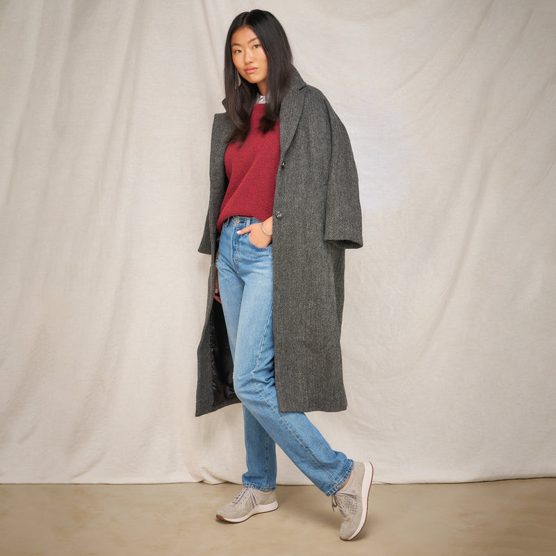 A woman in autumn attire wearing grey sneakers.