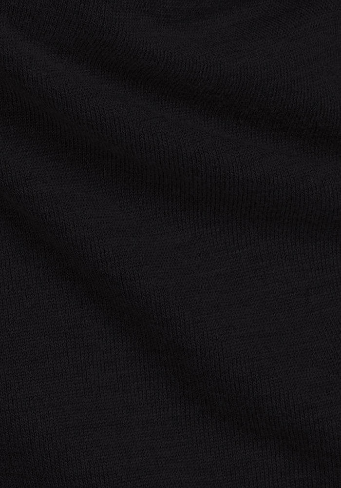 A close-up of the Woolx Chessy Tank Top - Black highlights its fine, ribbed knit texture and subtle folds—perfect as a sleek layering piece or a versatile sleeveless sweater.
