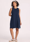 Smiling woman in Woolx Clara Dress • Final Sale - Deep Navy, white headband, and sneakers against a plain light background.