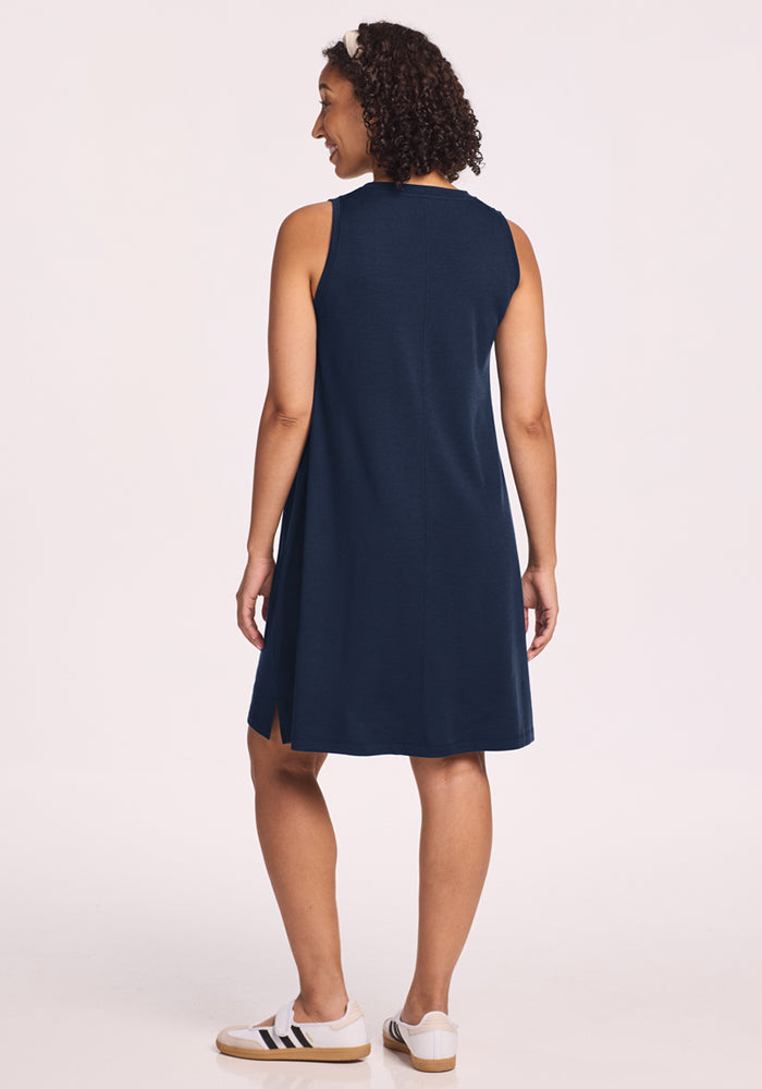 Woman wears the Woolx Clara Dress in Deep Navy and white sneakers, facing away against a plain background.