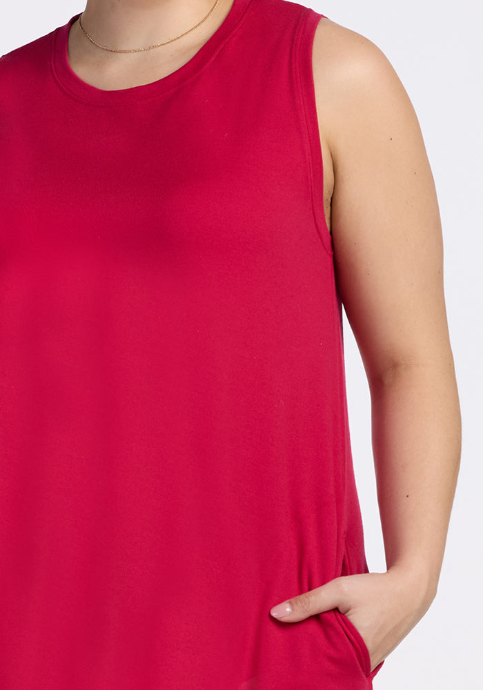 Model wears Woolx Clara Dress in Poppy Spark, bright pink, lightweight and breathable, shown shoulders to hips.
