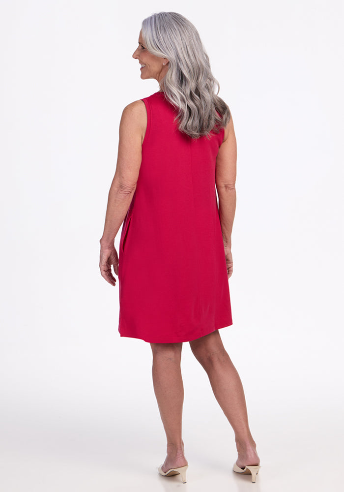 Older woman with long gray hair wears the Woolx Clara Dress in Poppy Spark, standing and facing away.