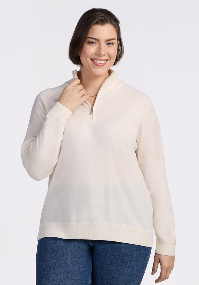 A woman with short brown hair smiles at the camera, wearing Woolx's Collins Half Zip Sweater in Dewdrop Pearl and blue jeans against a plain white background. | Juliana is 5'10", wearing a size XL