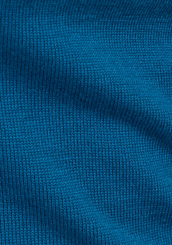 Close-up of the Woolx Collins Half Zip Sweater in Moroccan Blue, highlighting detailed knit stitches and soft merino wool folds for depth and comfort, plus antimicrobial, odor-resistant properties.