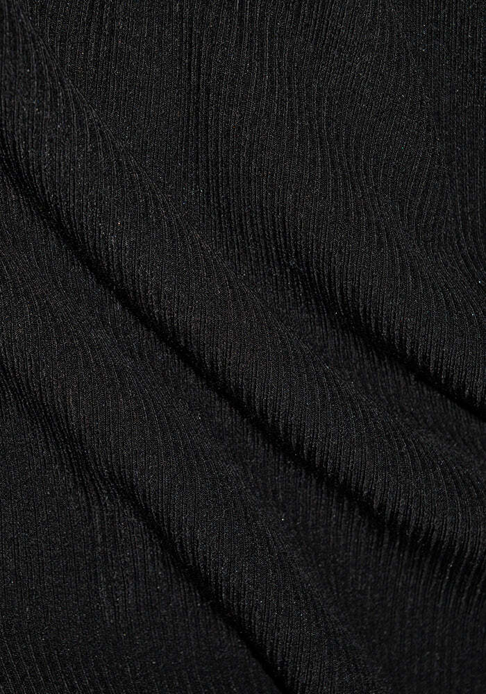 Close-up of the Delia Ribbed Short Sleeve - Black by Woolx, featuring a black ribbed Merino wool fabric with diagonal lines and a textured surface, creating subtle shadows and highlights.