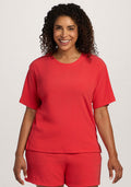 Smiling woman in the Woolx Delia Ribbed Short Sleeve - Hibiscus, standing against a plain background. | Kisha is 5'8", wearing a size M