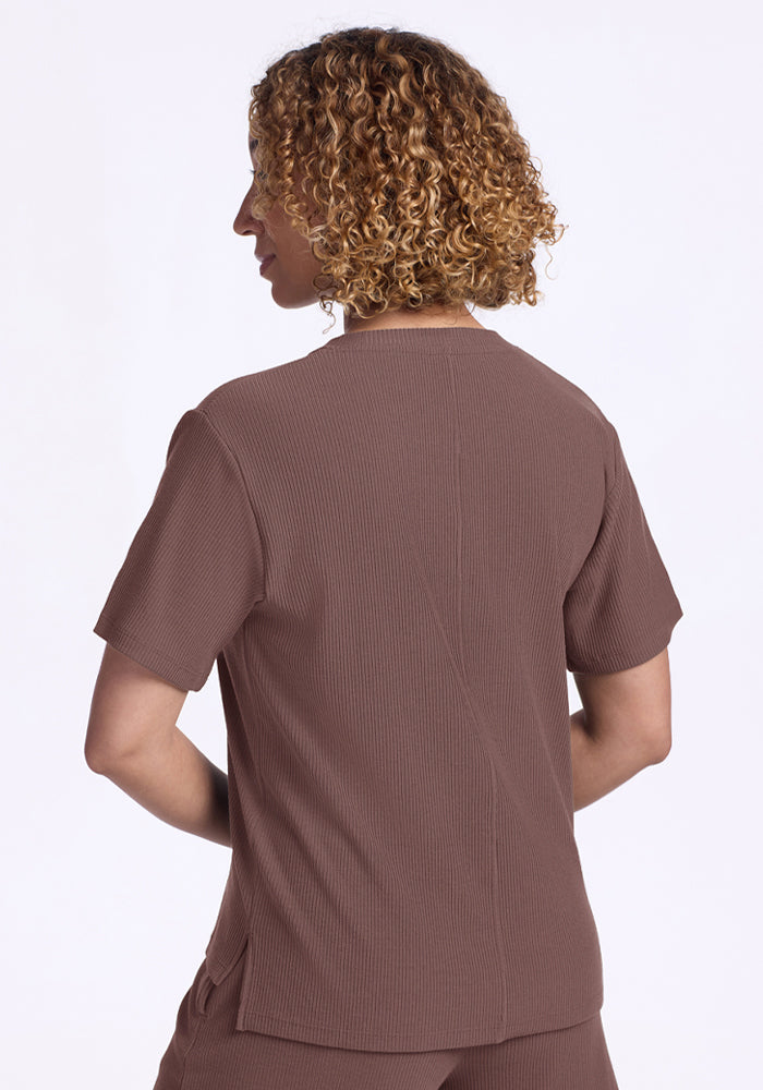 Person with curly hair wearing the Woolx Delia Ribbed Short Sleeve in Peppercorn, shown from the back.