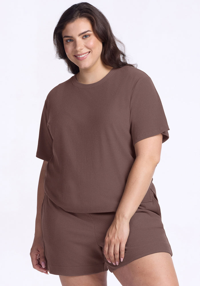 Woman smiles in Woolx Delia Ribbed Short Sleeve in Peppercorn and matching shorts against a plain light background. | Juliana is 5'10", wearing a size XL
