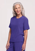 Older woman with long gray hair smiles, wearing the Woolx Delia Ribbed Short Sleeve in Berry Indigo. | Tam is 5'8.5", wearing a size S
