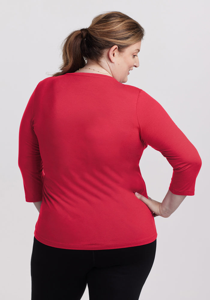 Woman with light brown hair in a ponytail, wearing Woolx Elena 3/4 Sleeve V Neck in Berry Ice Pop, facing away.