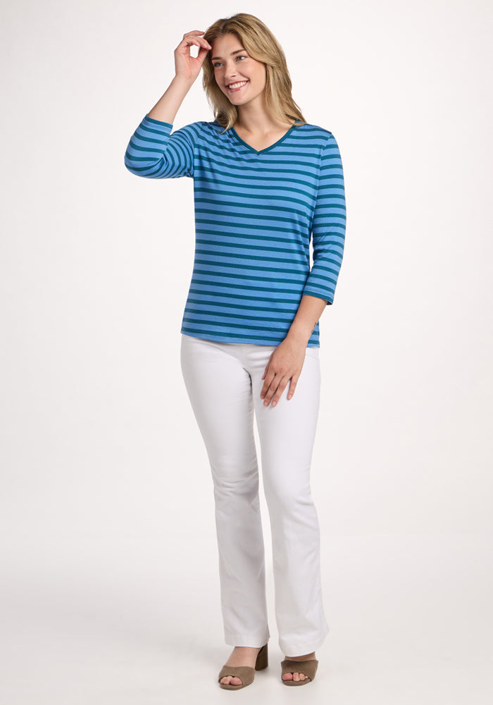 Woman smiles in Woolx Elena 3/4 Sleeve V Neck - Coastal Stripe, white pants, and brown heels on a white background.