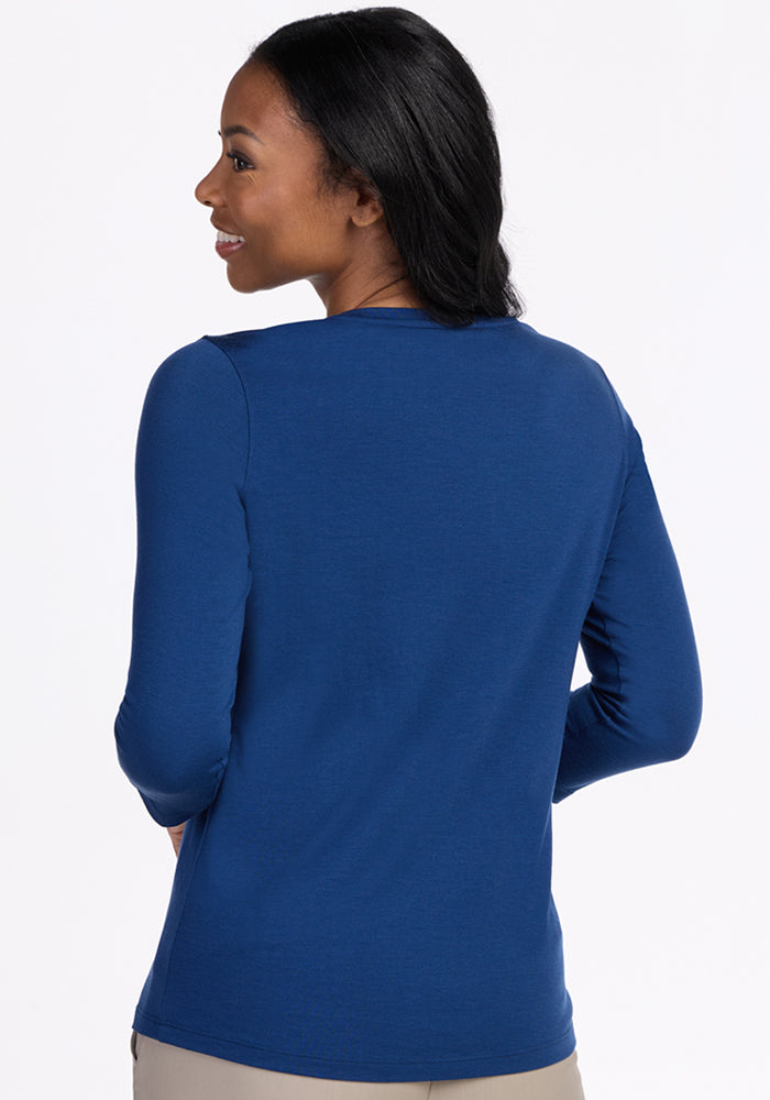 Woman smiling, wearing the Woolx Elena 3/4 Sleeve V Neck in Estate Blue, shown from the back on a white background.