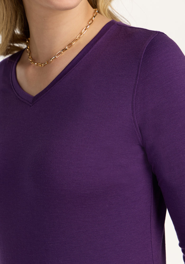 Woman wears a gold chain and Woolx Elena 3/4 Sleeve V Neck in Plum Crush, shown from shoulders to mid-chest.